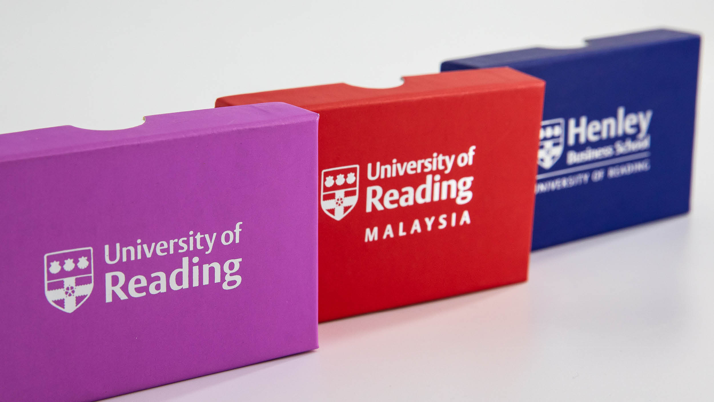Collection of three presentation boxes featuring foiled University of Reading, UoR Malaysia and HBS logos