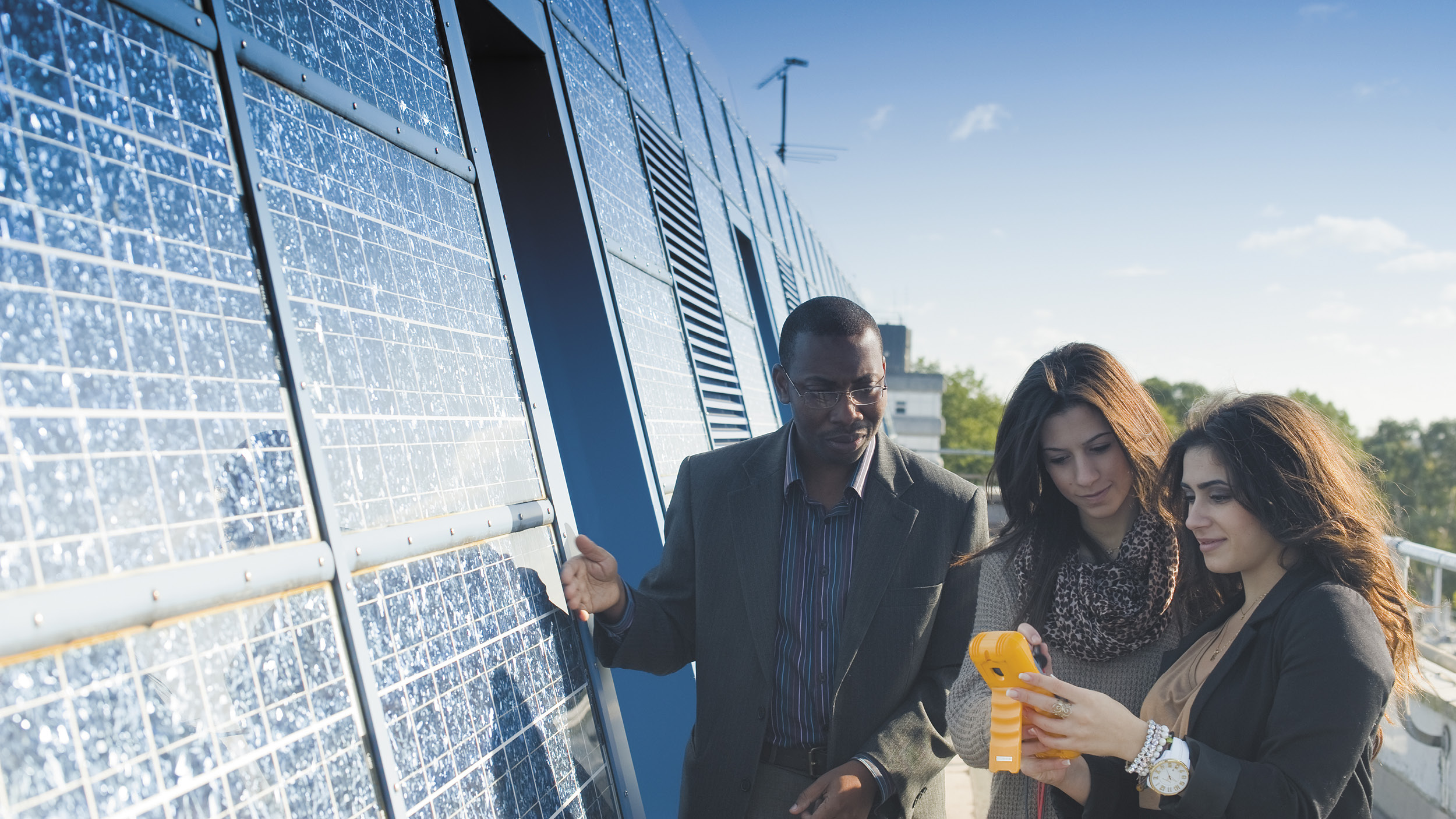 Students examine solar panels on campus