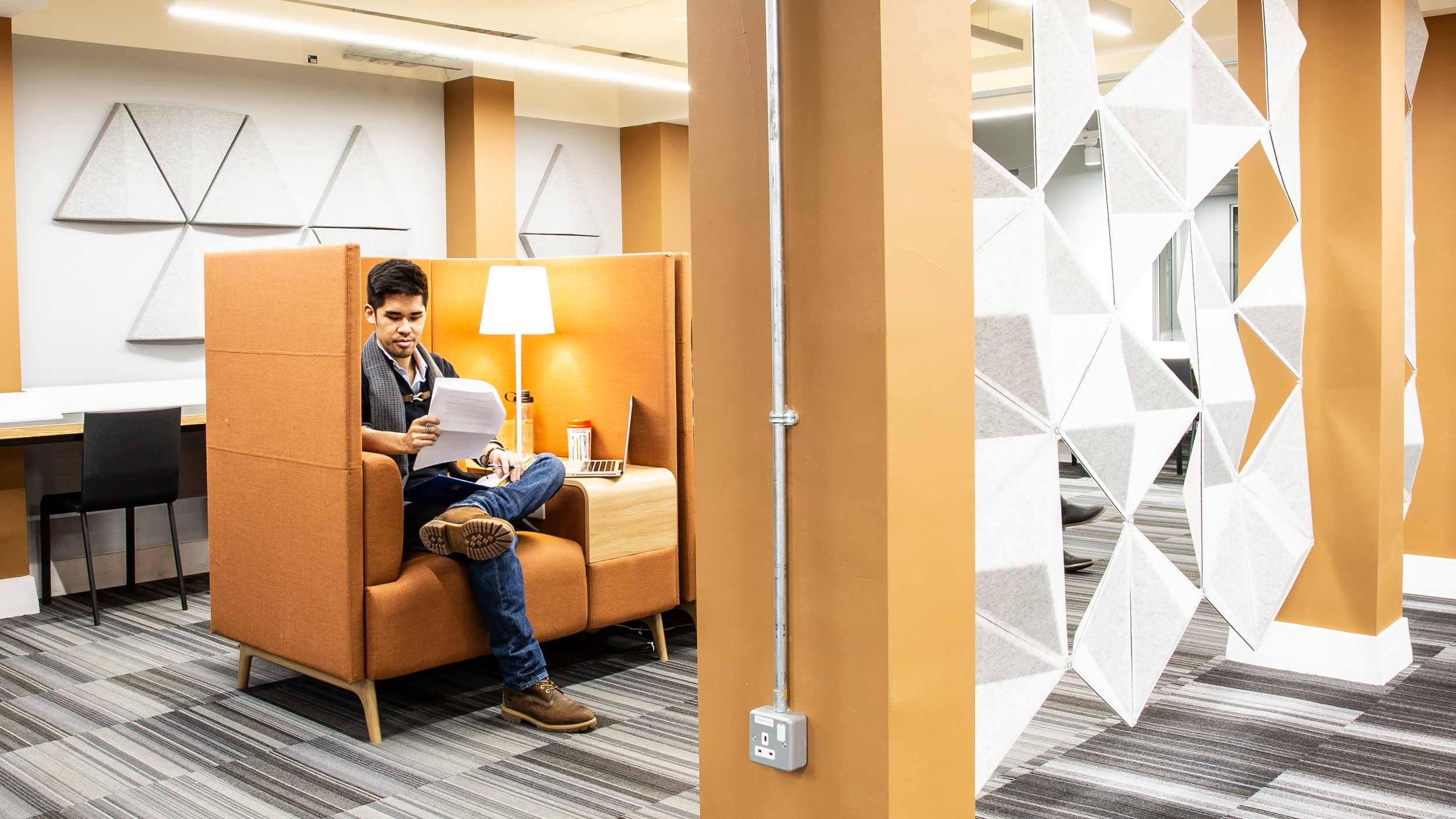 Male student reads in a booth in the library