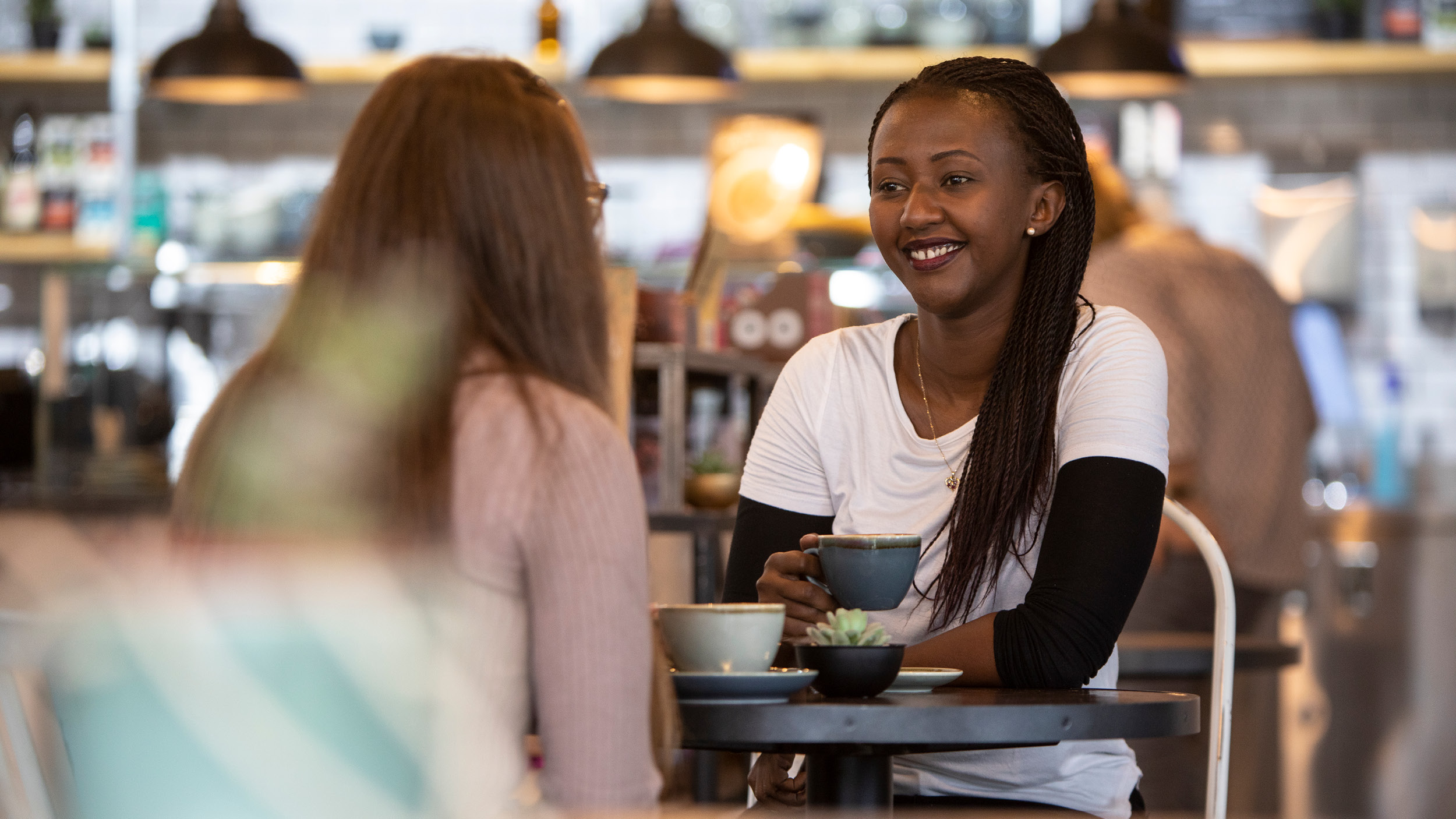Two female students chat over coffee in the Dolche Vita cafe