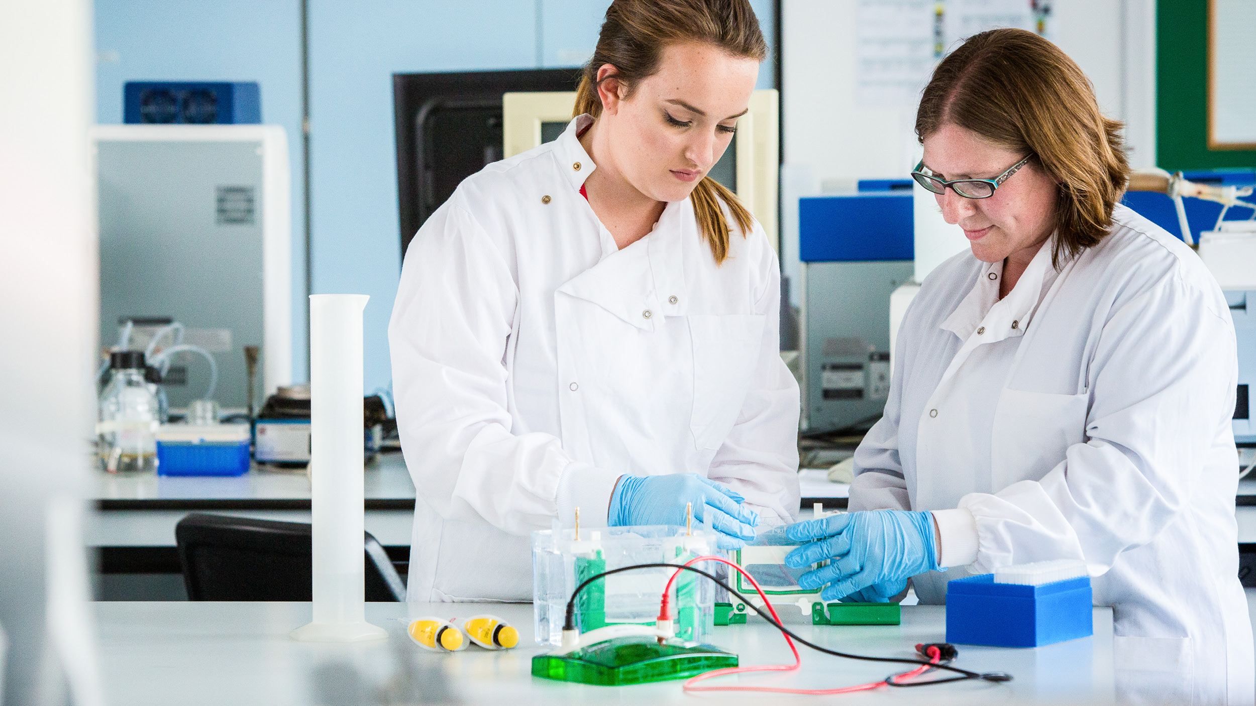 A female student works with a supervisor in a lab