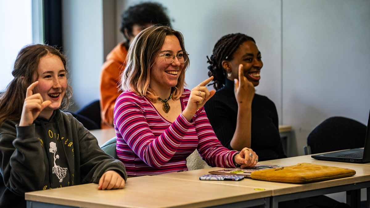People smiling during a British Sign Language workshop
