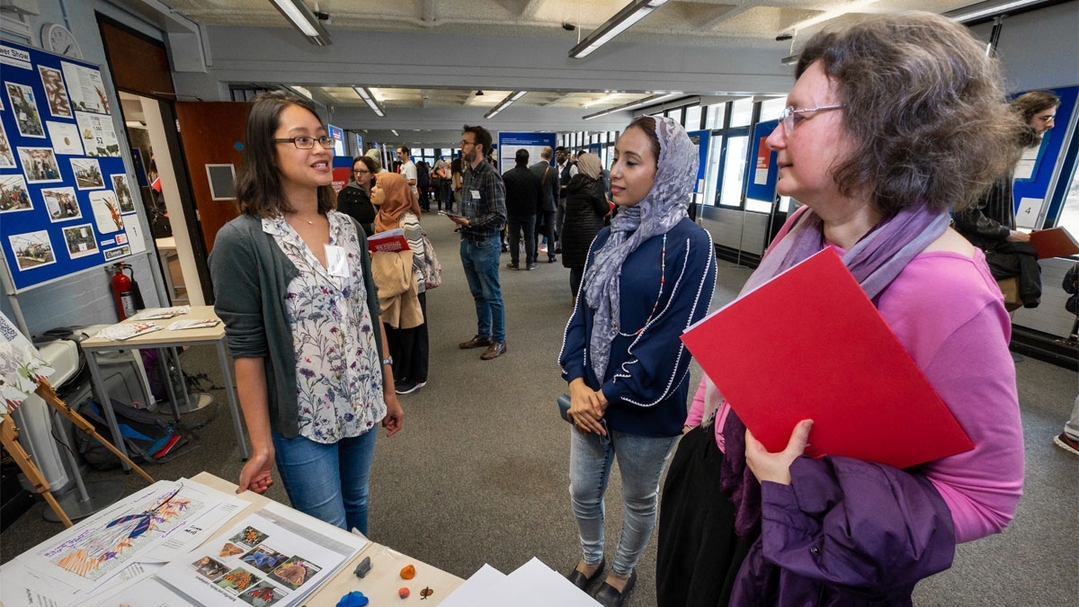 PhD students presenting their research at a poster event