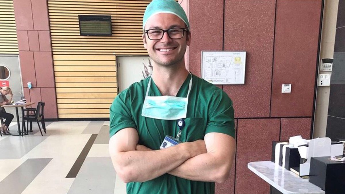James Cutlan smiling, dressed in scrubs
