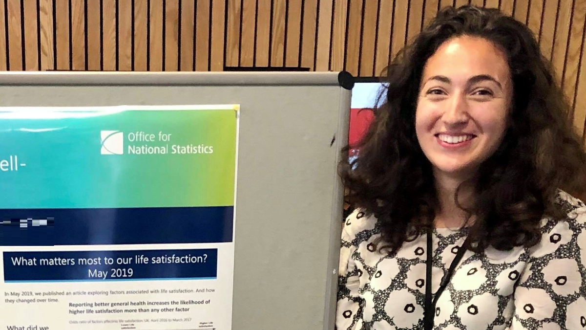 Meera Parmar standing next to aa poster for Office for National Statistics