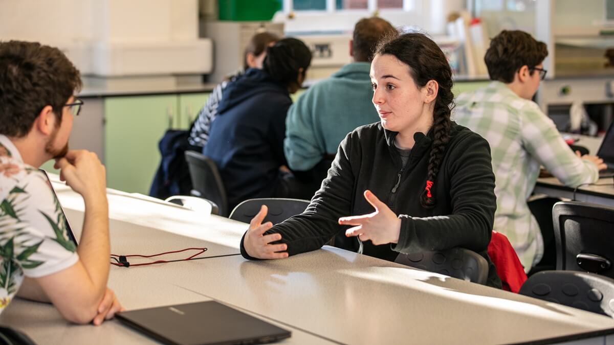 Two people speaking across a desk