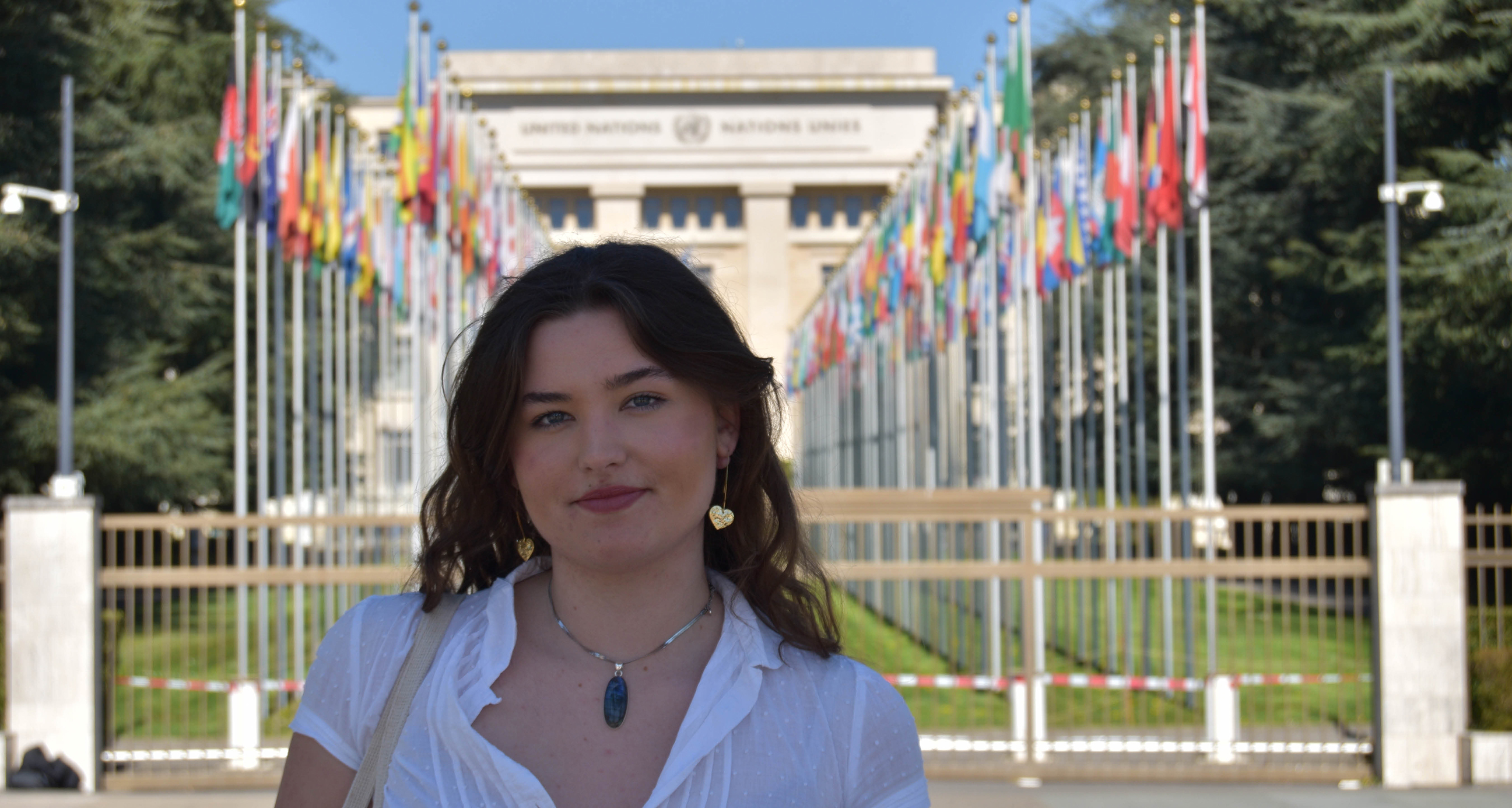 Student Megan standing in front of a row of flags