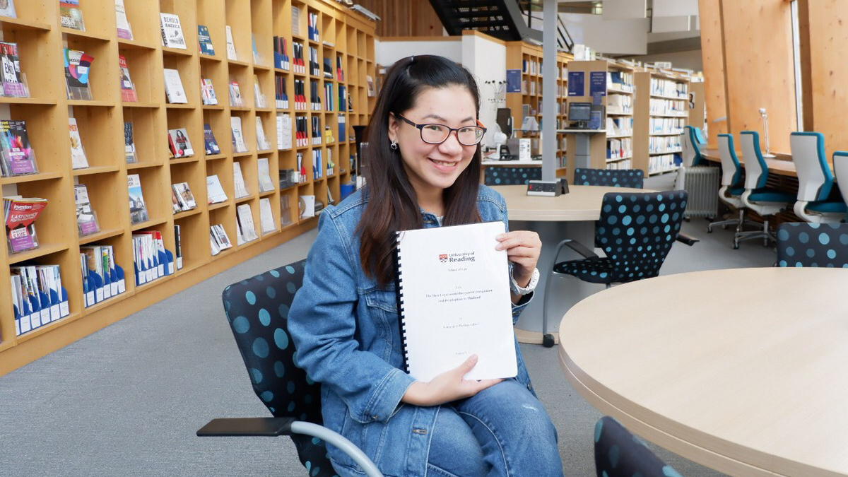 A photo of NAttapapin holding her final thesis 