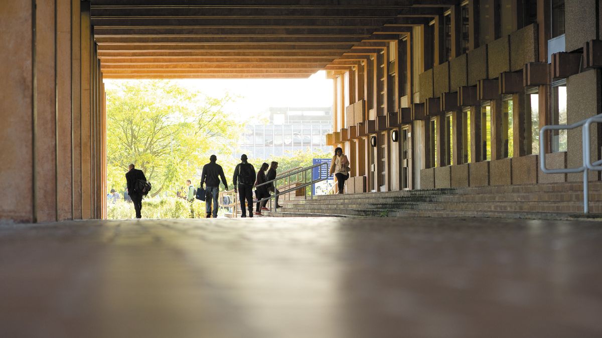 People walking outside next to the URS Building, University of Reading campus.